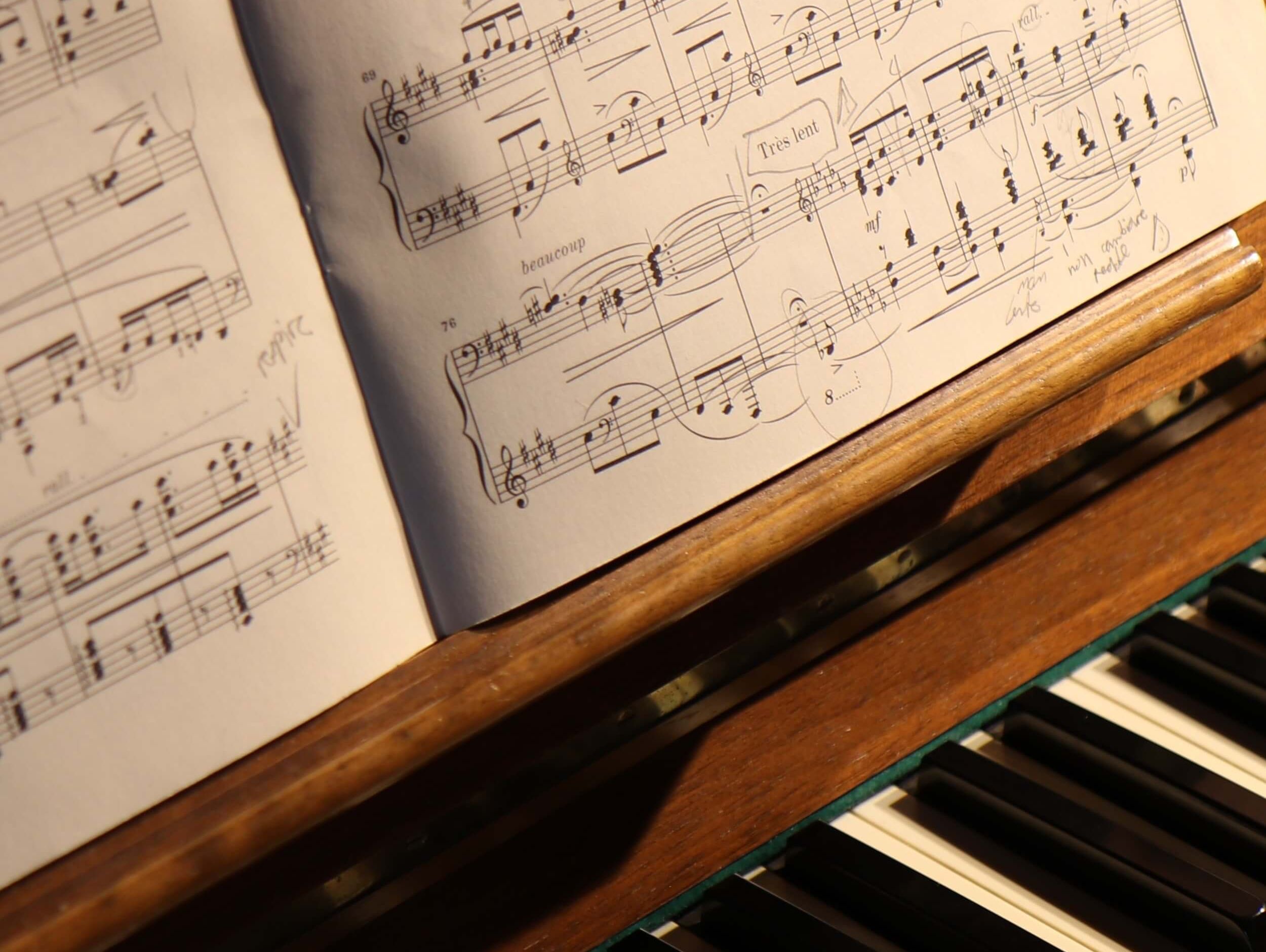 Noten liegen auf einem Holzklavier, bereit zum Spielen.