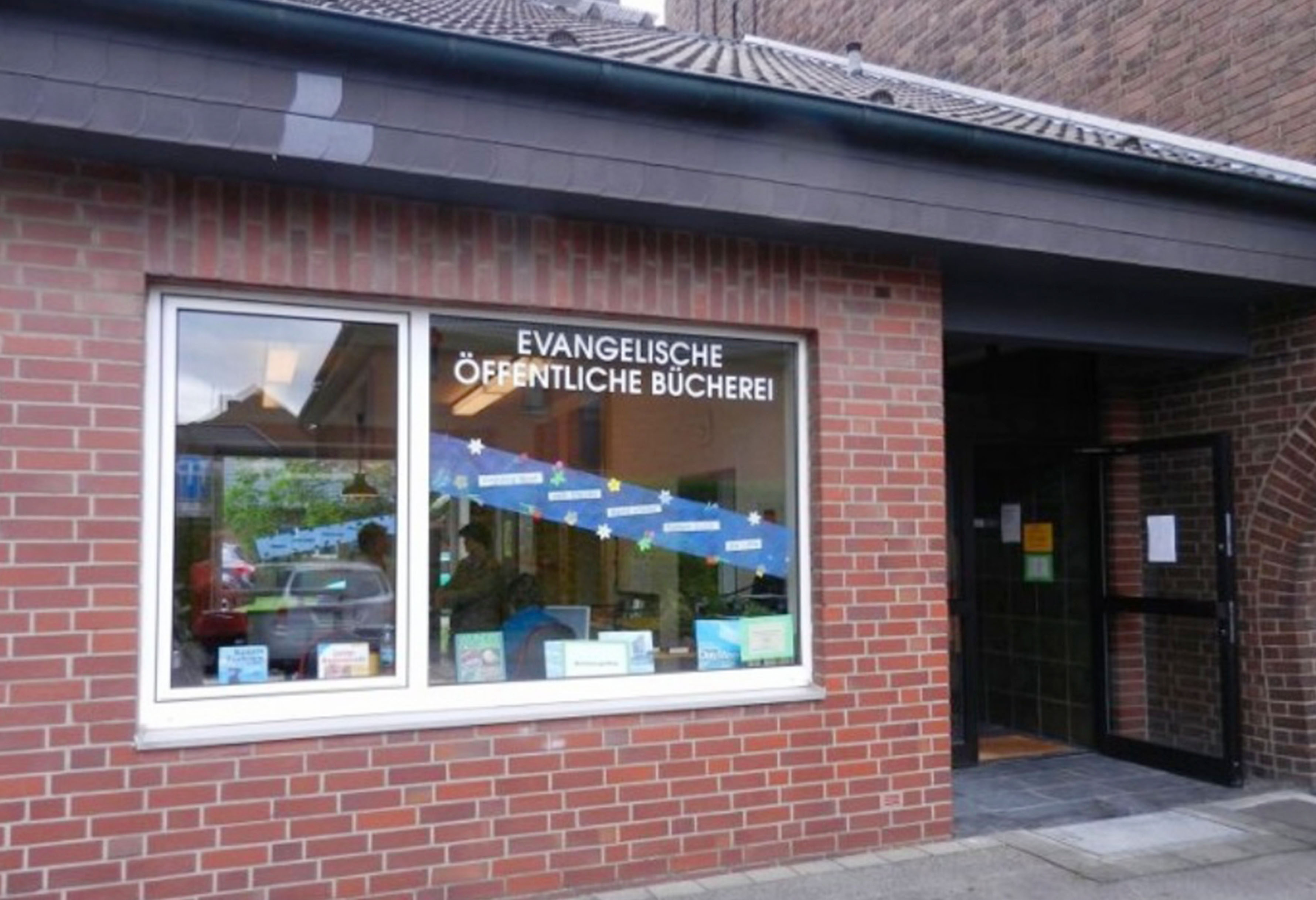 Evangelische öffentliche Bibliothek, Ziegelgebäude, Schaufensterauslage, offene Tür.