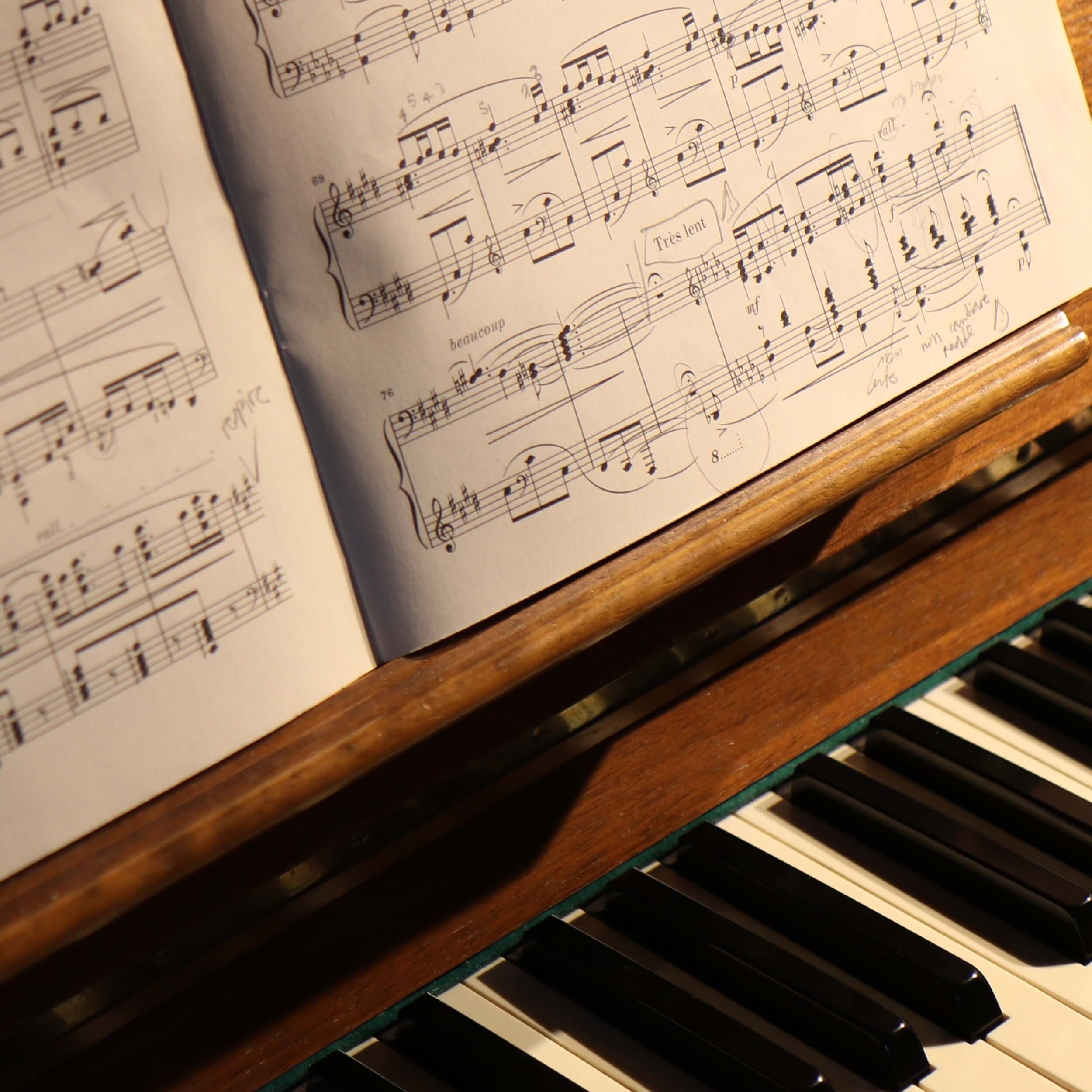 Noten liegen auf einem Holzklavier, bereit zum Spielen. Sources Analysis